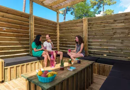 Des amis prennent l'apéritifs sur la terrasse d'un mobil home haut de gamme au cap ferret